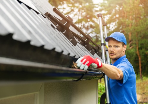 Worker pulling leaves out of gutter for gutter cleaning in Washington IL