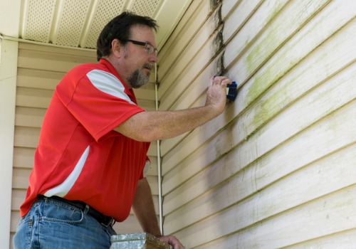 A man using a soft brush for Siding Cleaning in East Peoria IL