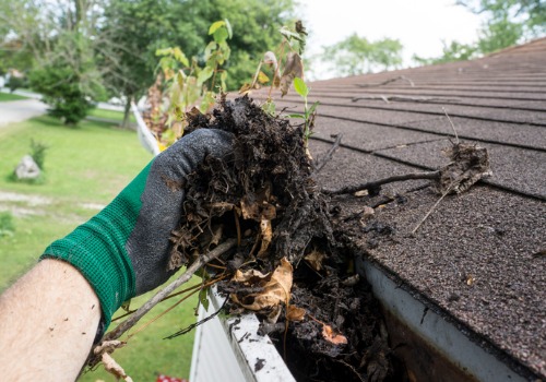 A man pulling debris about of gutters during Gutter Cleaning in East Peoria IL
