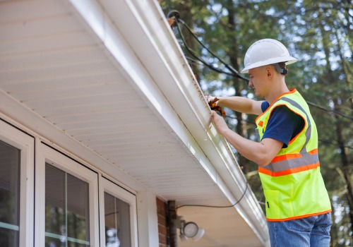 A team member of Flush the Guts, one of the best Gutter Cleaning Companies in Peoria IL, works on cleaning gutters.